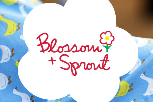 Blossom + Sprout logo on a white flower over duck pattern fabric