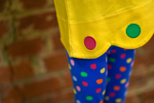 Girl's yellow scalloped tunic with colored circle appliqués