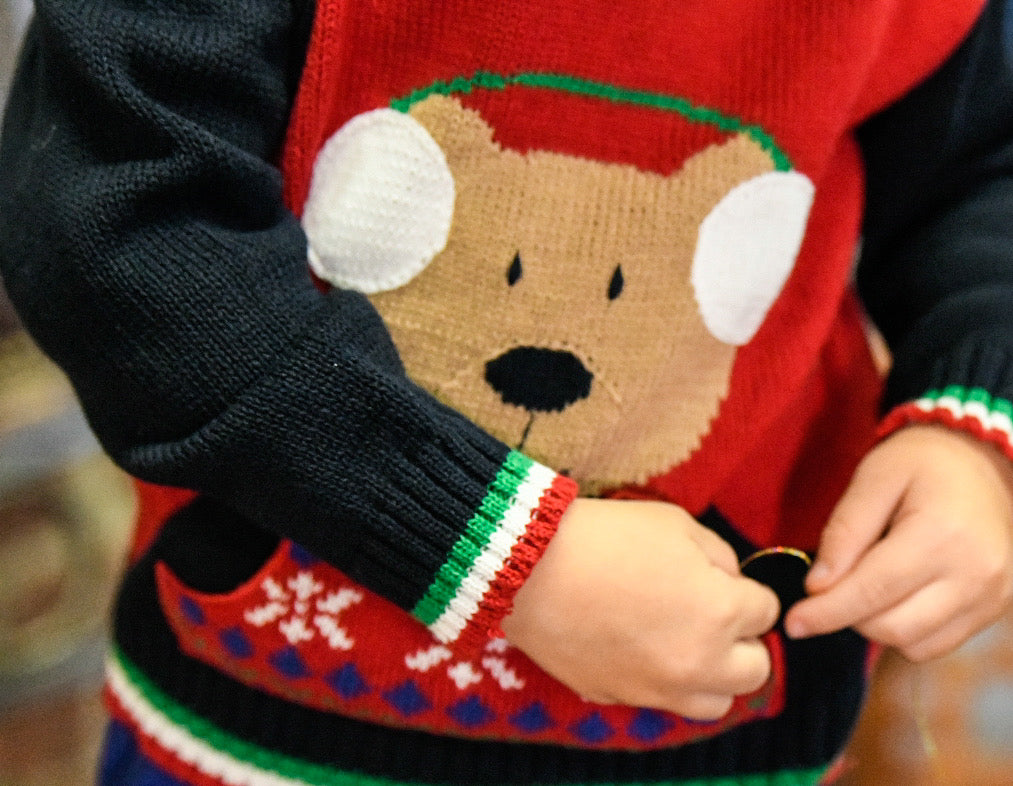 close-up shot of a sweater depicting a bear wearing earmuffs