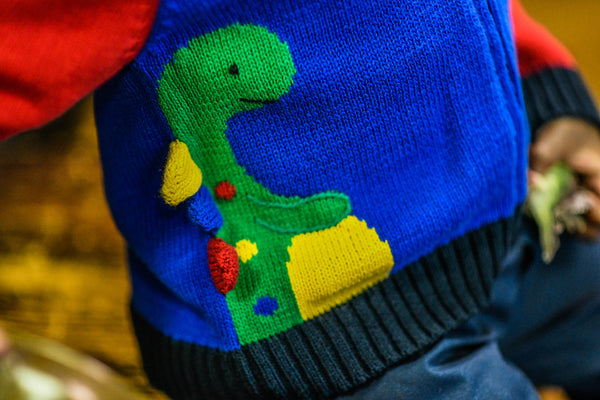 close-up of knit sweater with dinosaur