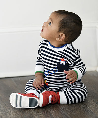 toddler boy sitting on the floor in a black and white stripe firetruck longall