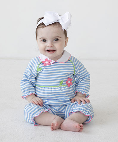 baby girl in blue and white stripe longall and a white bow on her head