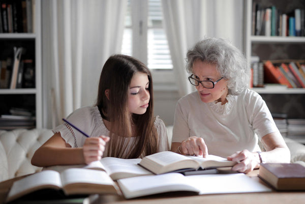 grandmother and granddaughter looking at books