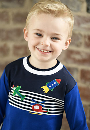 young boy in a navy, black and white stripe long sleeve shirt with appliqués