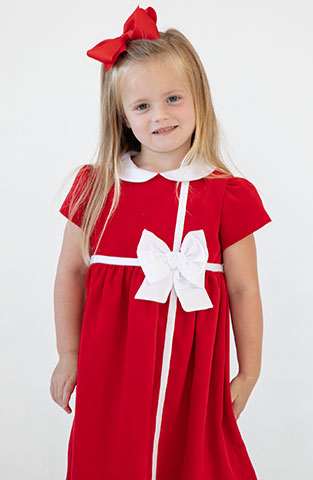 young girl in red velvet dress and white bow
