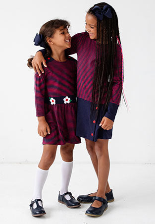 sisters wearing red and blue stripe dresses