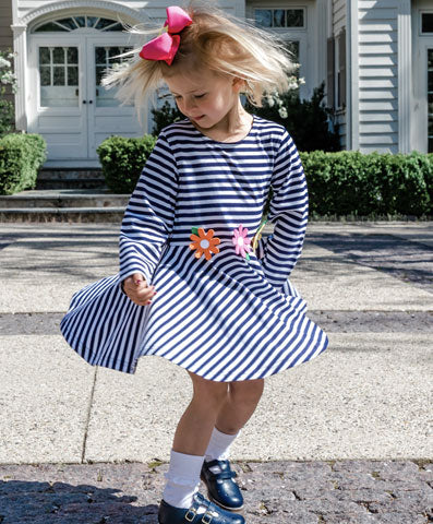 girl twirling in a stripe circle skirt with flower appliqué